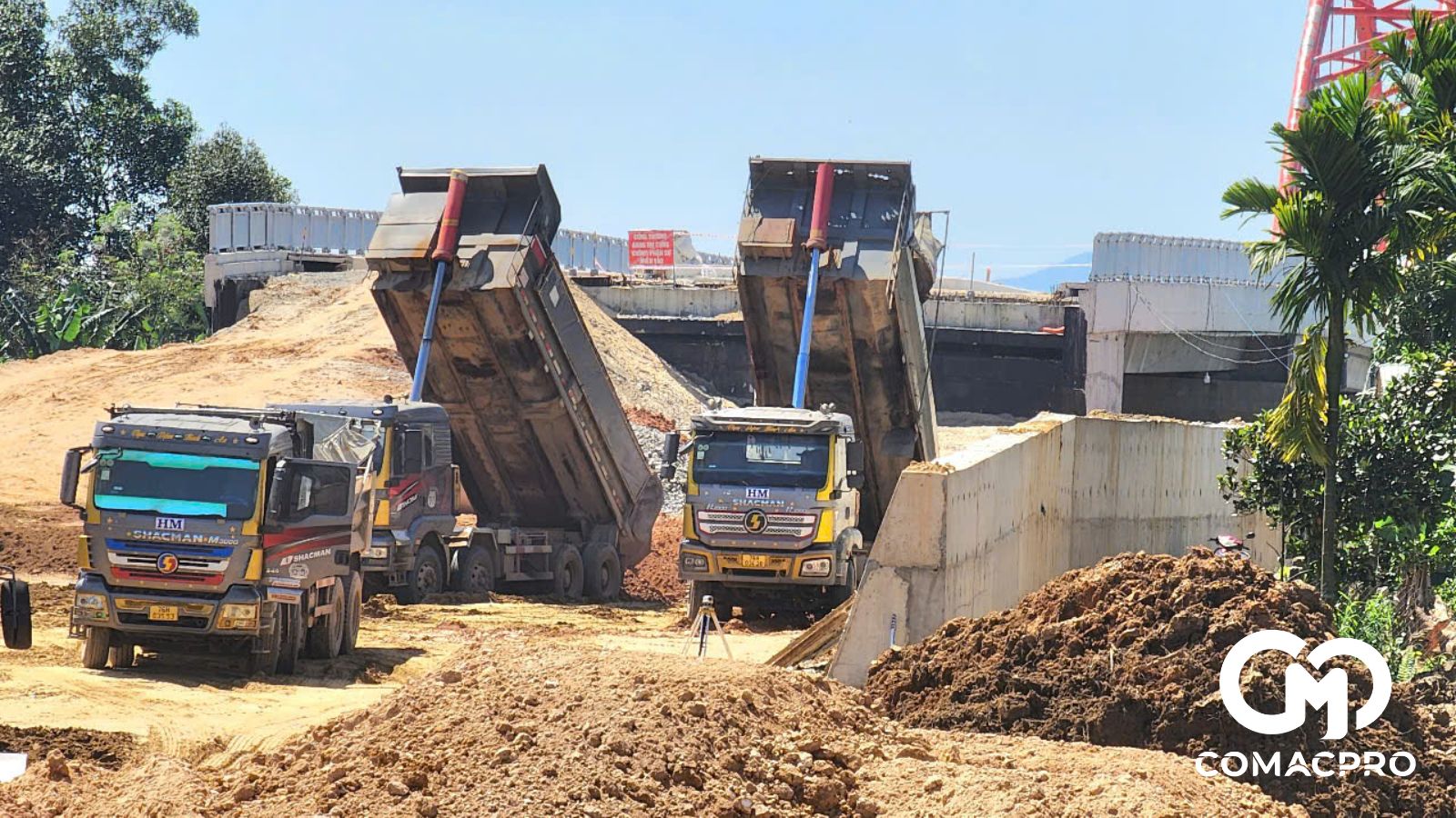 Sáng 3/3, tranh thủ thời tiết nắng ráo, các nhà thầu tăng tốc đẩy mạnh công tác thi công. Công trường dự án rầm rập tiếng thiết bị cơ giới. Những chiếc xe tải chở đất đắp vừa "nhả hàng" tức thì đội xe ủi, xe lu tiến đến tiếp cận công địa.